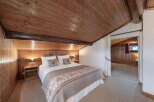 Experience rustic charm in this cozy bedroom featuring a beautifully crafted wooden ceiling and walls, creating a warm and inviting atmosphere.