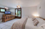 This charming bedroom features a comfortable queen-size bed adorned with decorative pillows and a floral-patterned bedspread.