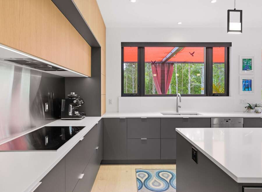 Experience modern luxury in this stunning kitchen, featuring sleek dark gray cabinetry complemented by warm wood accents.