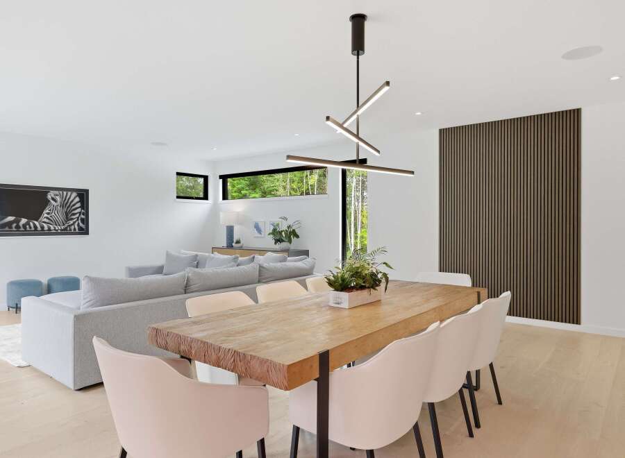 Experience modern living in this open-concept dining and living area, featuring a stunning live-edge dining table and plush seating.