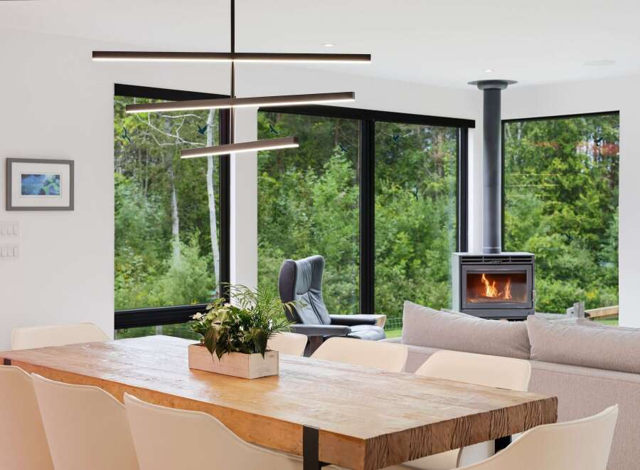 Experience modern living with this stunning open-concept space, featuring a large wooden dining table perfect for gatherings and a cozy fireplace for warm evenings.