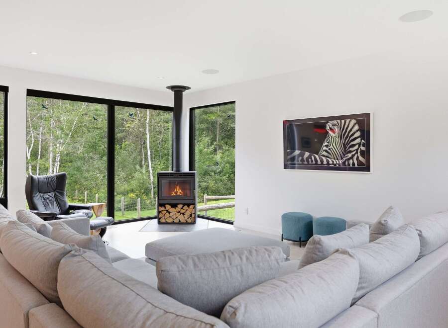 Experience modern living in this stunning home featuring a sleek fireplace and expansive windows that bring the outdoors in.