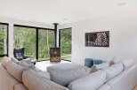 Experience modern living in this stunning home featuring a sleek fireplace and expansive windows that bring the outdoors in.