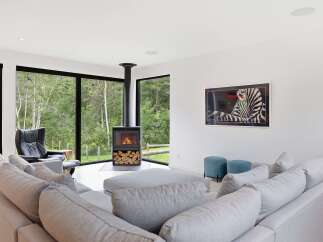 Experience modern living in this stunning home featuring a sleek fireplace and expansive windows that bring the outdoors in.