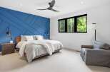 Experience luxury in this stunning bedroom featuring a striking blue accent wall with geometric paneling.