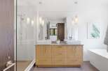Experience modern luxury in this stunning bathroom featuring a double vanity with vessel sinks and sleek wood cabinetry.