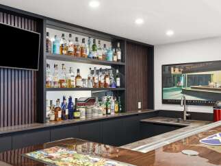 Elevate your entertaining with this stunning home bar, featuring a sleek modern design with ample shelving for a vast liquor collection.