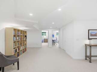 This spacious basement features a large, built-in bookshelf perfect for displaying your favorite reads.