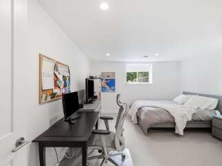 This modern bedroom offers a dedicated workspace with a sleek desk and ergonomic chair, perfect for productivity.