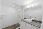 Experience modern luxury in this stunning bathroom featuring a spacious glass-enclosed shower with sleek tilework and a rainfall showerhead.