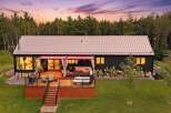 Experience modern living in this stunning home featuring a spacious wooden deck with a relaxing hot tub and comfortable outdoor seating.