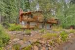 Nestled amidst towering trees, this charming mountain home offers a serene retreat with its multi-level decks and natural wood exterior.