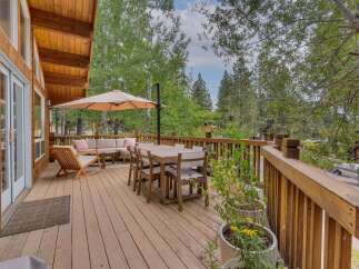 Enjoy outdoor living on this spacious wooden deck, perfect for entertaining or relaxing amidst nature.