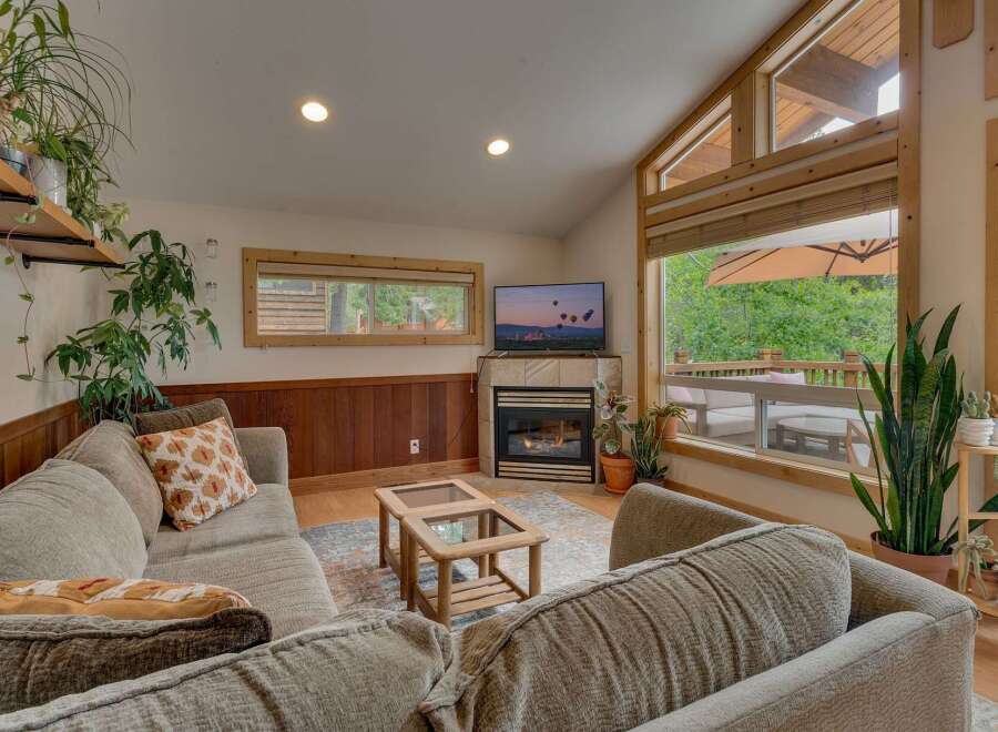 Experience cozy living in this inviting living room, featuring a warm fireplace and a large TV perfect for movie nights.