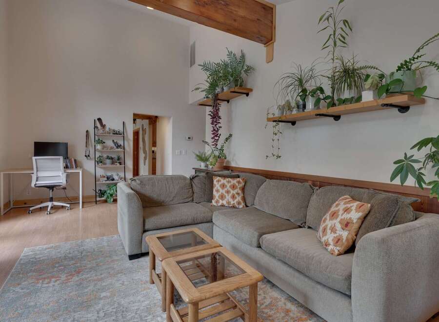This spacious living room features a large sectional sofa perfect for gatherings, complemented by two charming wooden coffee tables.