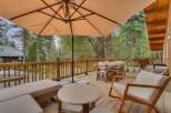 Enjoy outdoor living on this spacious wooden deck, perfect for entertaining or relaxing amidst a serene forest setting.