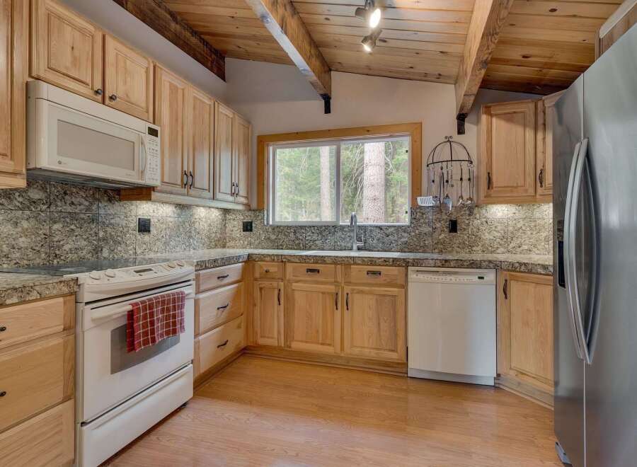 This charming kitchen features light wood cabinetry and granite countertops, offering a warm and inviting atmosphere.