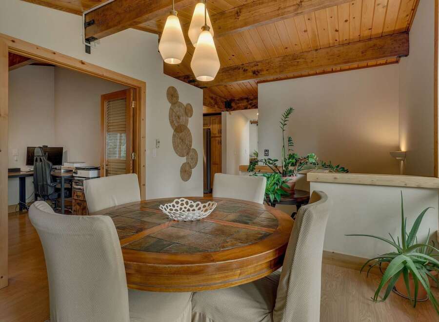 This inviting dining area features a round wooden table with a slate inlay, perfect for family meals.