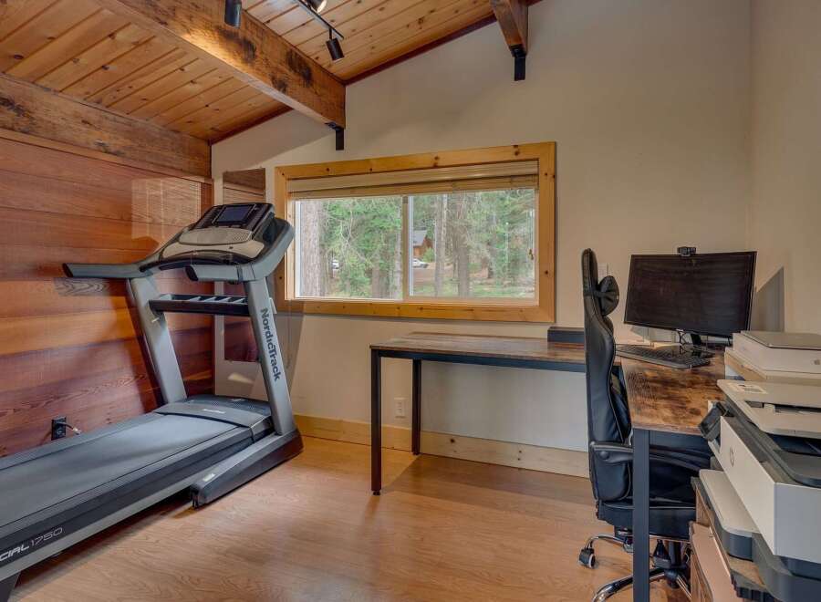 This room offers a perfect blend of fitness and productivity, featuring a NordicTrack treadmill for your workouts and a dedicated workspace with a computer and printer.
