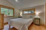 This charming bedroom features a comfortable queen-size bed adorned with plush white bedding and decorative pillows.