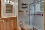 This charming bathroom features a light wood vanity with a white countertop and a modern sink.