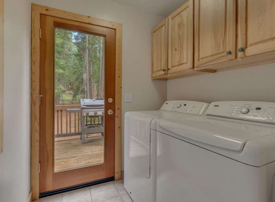 Step outside to a spacious deck with a grill, perfect for outdoor entertaining, accessible through a charming wooden door.