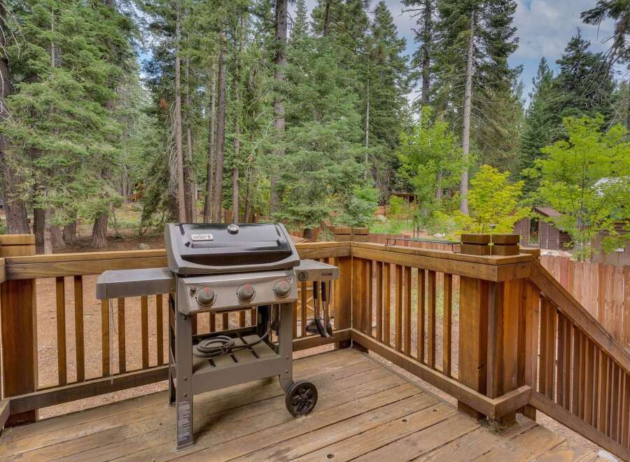 Enjoy outdoor living with this spacious deck, perfect for entertaining or relaxing amidst a serene forest setting.