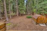 Discover this charming property nestled amongst tall pine trees, offering a serene and private backyard oasis.