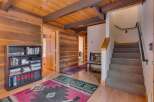 Step into this charming cabin-style entryway featuring warm wood paneling and exposed beams.