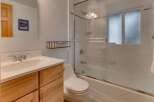 This bathroom features a modern vanity with ample storage and a sleek sink, complemented by a spacious bathtub and shower combination.