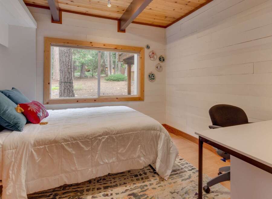 This cozy bedroom offers a comfortable queen-size bed adorned with plush pillows, perfect for a restful night's sleep.