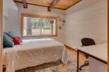 This cozy bedroom offers a comfortable queen-size bed adorned with plush pillows, perfect for a restful night's sleep.