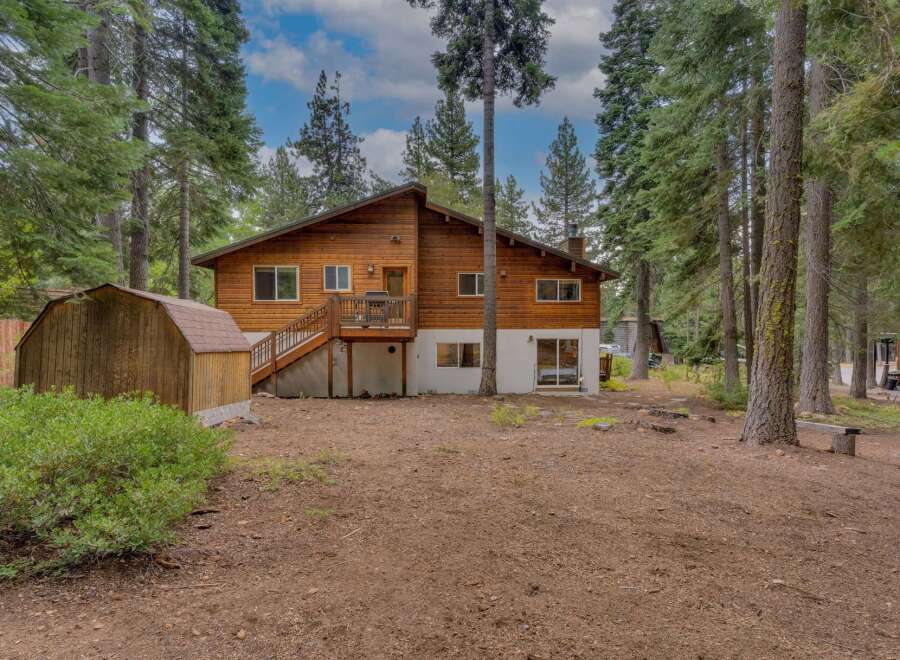 Nestled among tall pine trees, this charming wooden home offers a serene retreat.