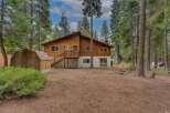 Nestled among tall pine trees, this charming wooden home offers a serene retreat.