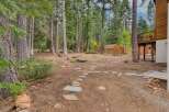 Discover your private oasis with this charming backyard, featuring a rustic stone pathway leading to a quaint wooden shed.