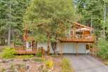 Nestled amongst tall trees, this charming home offers a serene mountain retreat.