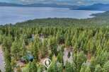 Nestled amidst a dense forest of pine trees, this property offers a serene retreat with stunning views of a vast lake and distant mountains.
