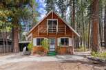 Charming A-frame cabin nestled amongst tall pine trees, offering a rustic retreat.
