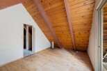 Discover the unique charm of this attic space, featuring a warm wooden plank ceiling and exposed beams that add rustic character.