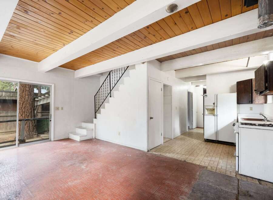 Discover the potential in this charming fixer-upper, featuring a rustic wood-beamed ceiling and a spacious open-concept living area.