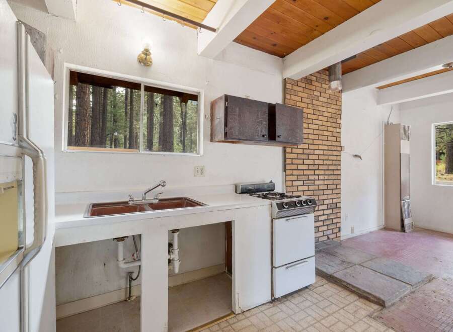 Discover a charming kitchen space with rustic wooden beams and a brick accent wall, offering a unique and cozy atmosphere.