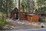 Nestled among tall pine trees, this charming cabin offers a serene mountain retreat.