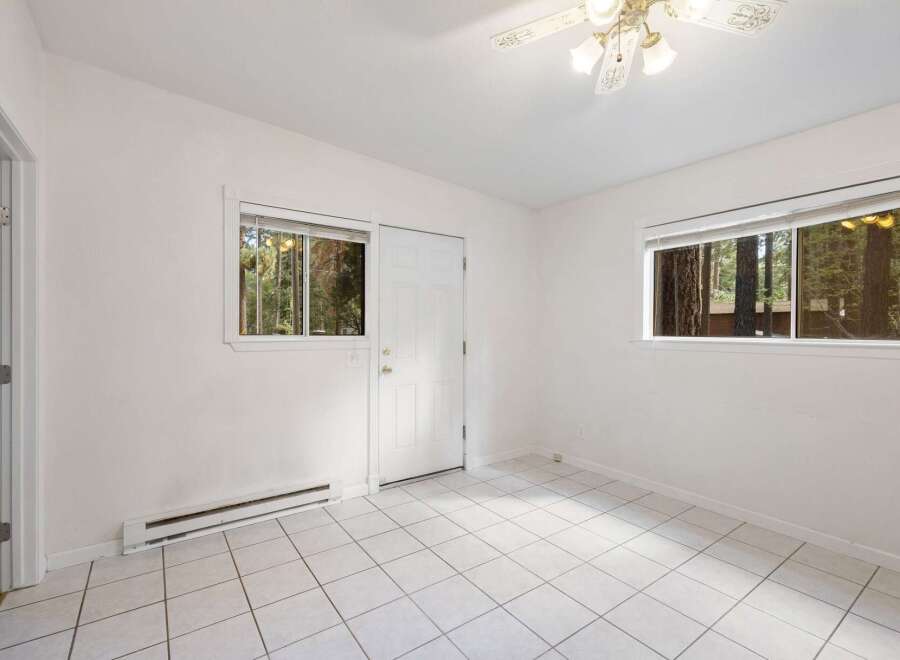 Discover a bright and airy room featuring crisp white walls and large windows that flood the space with natural light.