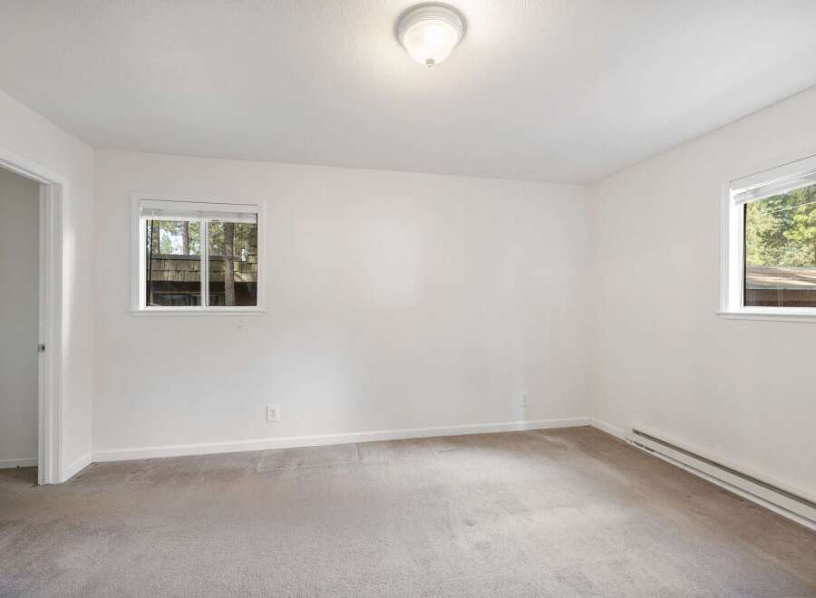 This spacious bedroom features neutral carpeting and crisp white walls, creating a bright and airy atmosphere.