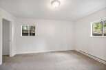 This spacious bedroom features neutral carpeting and crisp white walls, creating a bright and airy atmosphere.