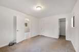 This spacious bedroom features neutral carpeting and ample natural light, creating a serene atmosphere.