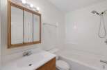 This bathroom features a clean and functional design with a white vanity and a large mirrored medicine cabinet.