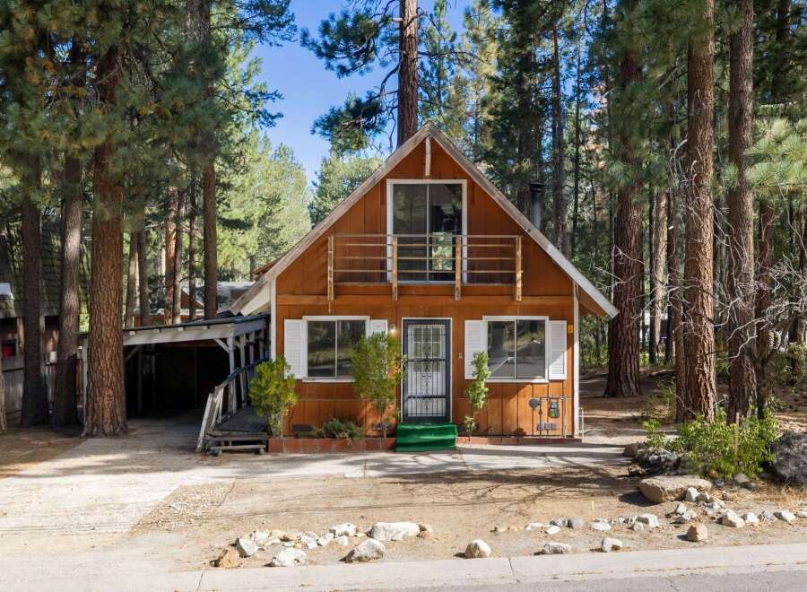 Nestled among tall pine trees, this charming wooden cabin offers a serene mountain retreat.