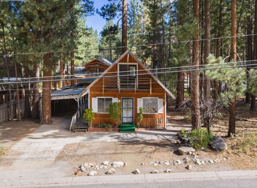 Nestled among tall pine trees, this charming wooden cabin offers a serene mountain retreat.