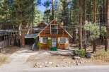 Nestled among tall pine trees, this charming wooden cabin offers a serene mountain retreat.